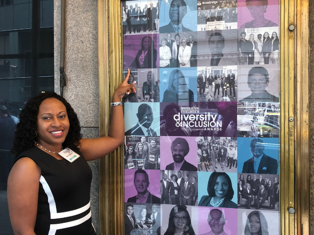 women pointing at her photo on a framed poster